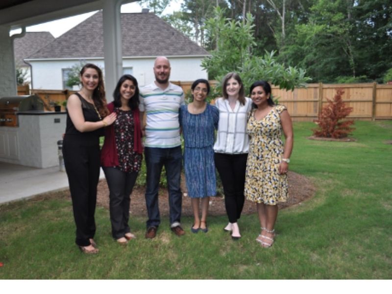 Group of students pose outside someone’s home.